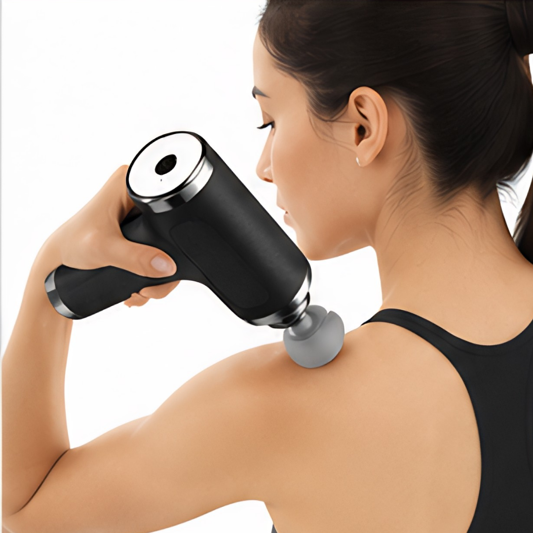 Woman using a handheld massage device on her shoulder against a white background